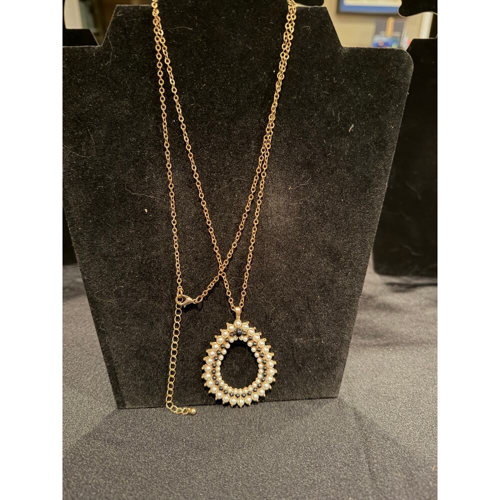 A beaded teardrop pendant 36-39”necklace, featuring gold tone pendant